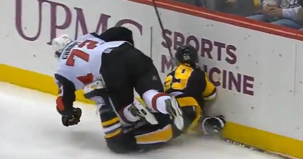 Jake Guentzel goes head first into the boards after scoring a goal.